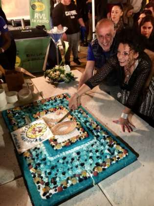 Cinzia Ferro taglia la torta 20 Anni insieme con Stefano e lo staff Estremadura Café.