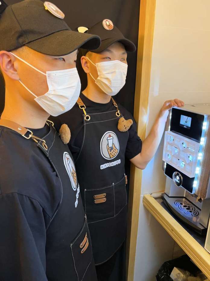I fratelli Tian Bao e Tian You nel loro locale con la macchina superautomatica di Rhea rhTT1